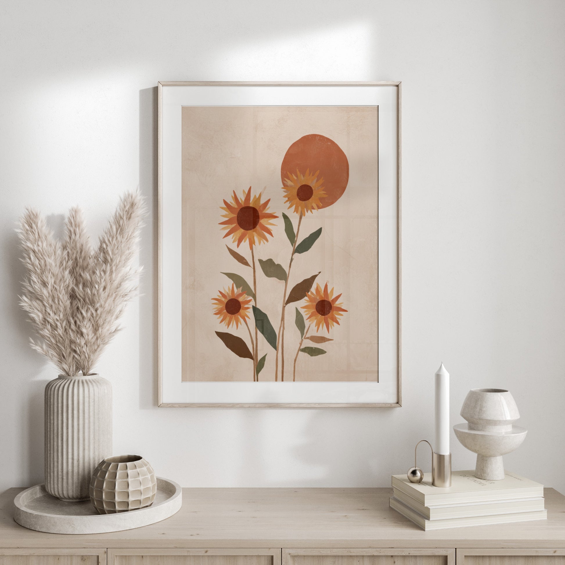Framed abstract art of sunflowers and a sun against a textured cream background.