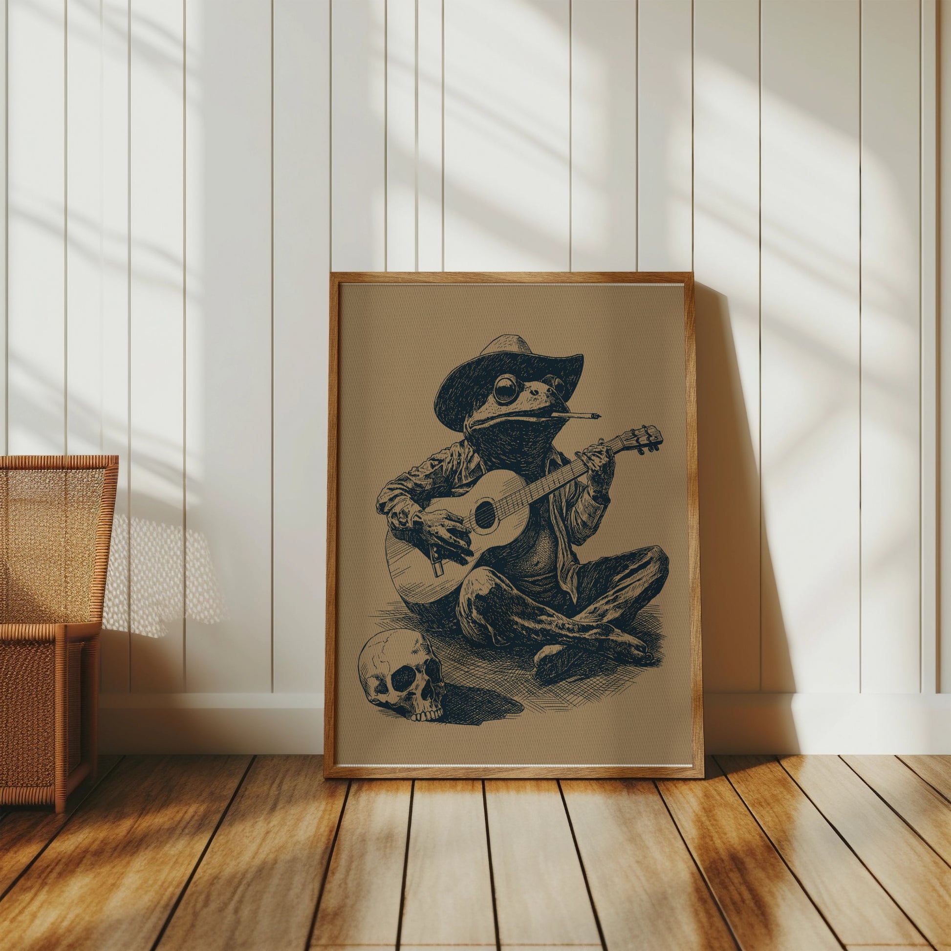 Framed sepia drawing of a frog in a cowboy hat playing guitar with a skull nearby.