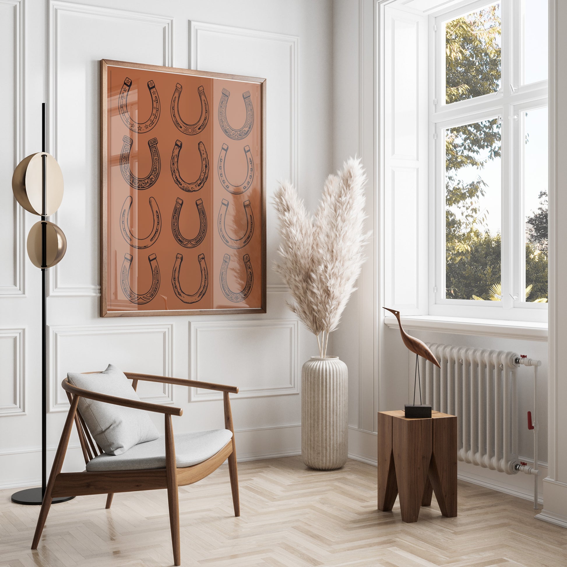 Framed art of horse shoes hanging on a wall above a chair.